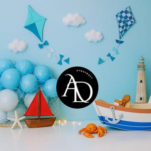 May include: A nautical-themed scene with a blue background, featuring a toy sailboat with a red sail, a lighthouse, and a toy boat with an anchor. Kites and clouds decorate the backdrop. A crab and starfish are also present. The logo "ATOSCRAFT" is in the center.
