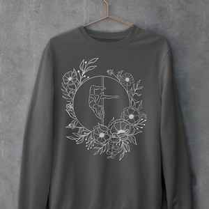 May include: A charcoal gray sweatshirt with a white outline of a person doing a pole dance surrounded by flowers.
