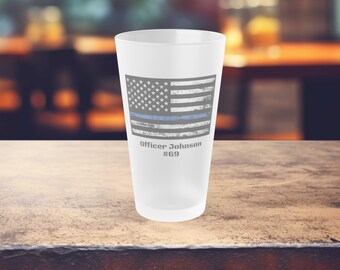 May include: A white frosted glass with a blue line American flag design and the text "Officer Johnson #69".