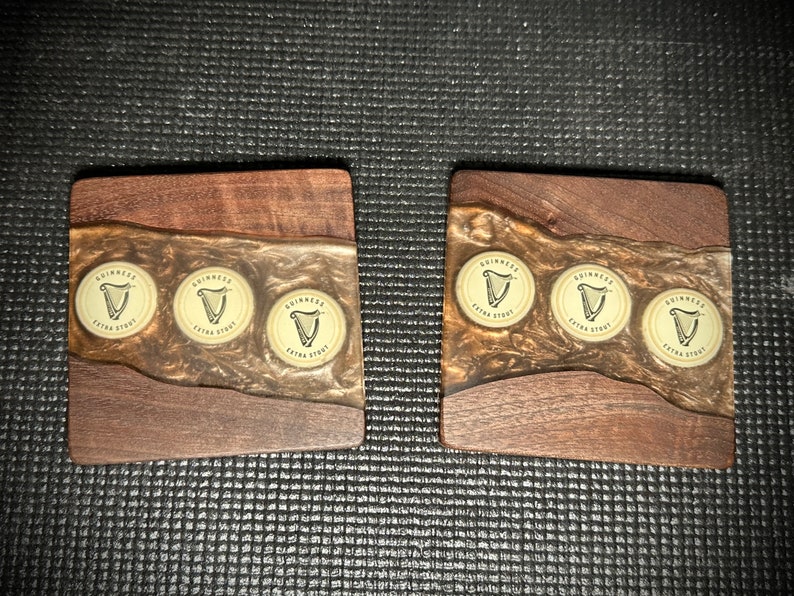 Pu&ograve; includere: Tre sottobicchieri in legno con un top in resina epossidica trasparente. Ogni sottobicchiere presenta tre tappi di bottiglia Guinness Extra Stout incorporati nella resina.