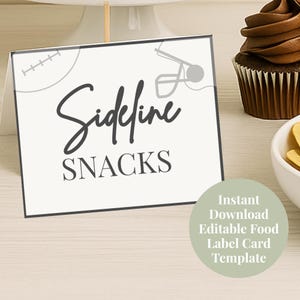 Op de afbeelding: Een witte kaart met de woorden "Sideline SNACKS" in zwarte letters en blokletters, met een voetbal- en helm-afbeelding. Een groene cirkel met tekst staat in de rechter benedenhoek. Een cupcake en een kom staan op de achtergrond.