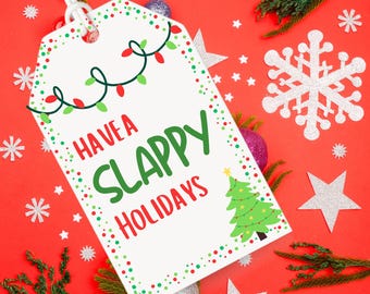 Könnte beinhalten: Weißer Geschenkanhänger mit roten und grünen Punkten und einem Weihnachtsbaumdesign. Der Anhänger lautet "Have a Slappy Holidays".