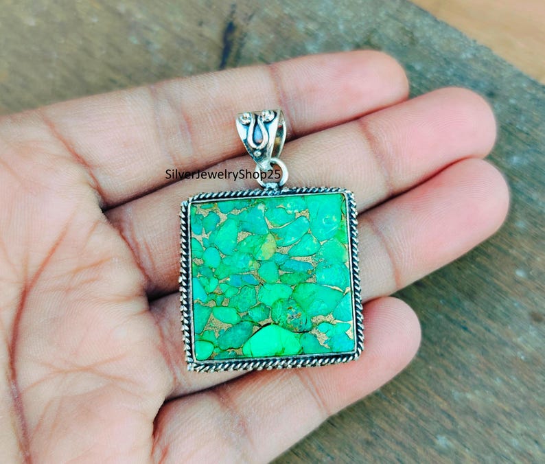May include: A silver pendant with a square turquoise stone. The stone is a mosaic of green and blue turquoise pieces.
