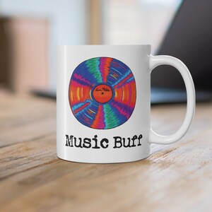 May include: White ceramic mug with a colorful vinyl record design and the text "Music Buff" printed on the front.