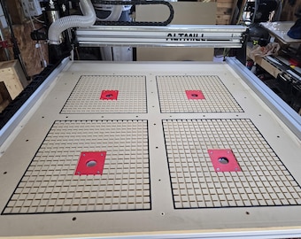 May include: A CNC machine with a light wood work surface. The surface has four square sections with a grid pattern and red inserts. The machine's frame is silver, and the name "ALTAMILL" is visible.