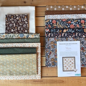 May include: A collection of folded fabric squares and rectangles featuring various floral, botanical, and geometric patterns in shades of brown, green, blue, and cream, accompanied by a white paper guide titled Maisons de Patchwork.