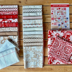 May include: A collection of folded fabric squares in red, white, and beige, featuring floral, plaid, and alphabet patterns. A Vintage Scrapworks instruction booklet is included, displaying quilt designs with red and blue accents on a wooden surface.