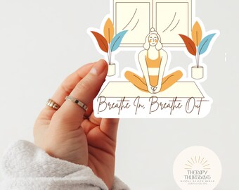 May include: A sticker with a woman sitting in a yoga pose in front of a window. The sticker has the text "Breathe In. Breathe Out" and a small logo that says "Therapy Thursdays Mental Health Merch" in the bottom right corner.
