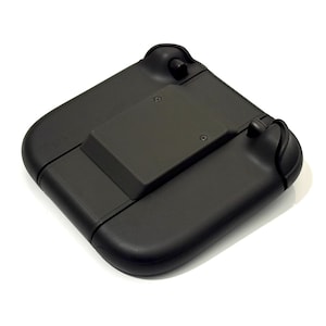 May include: A black, foldable electronic device with rounded edges and a central rectangular component. The device has two curved handles with loops. The object is set against a white background.