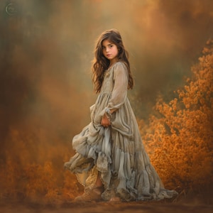 May include: A young person in a flowing, light gray dress with long sleeves and ruffled skirt, standing in a field of orange and brown foliage. The dress has a delicate, ethereal quality, and the person has long, wavy brown hair.
