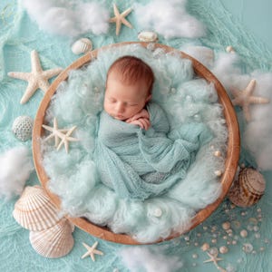 May include: A newborn baby swaddled in a light blue wrap, nestled in a wooden bowl filled with soft, light blue fluff. The scene is decorated with seashells, starfish, and faux pearls, creating a serene, ocean-themed setting for a baby photoshoot.