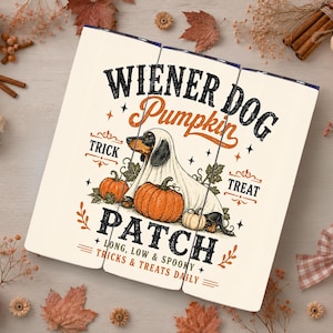 Peut inclure: Un gobelet blanc avec une illustration de teckel déguisé en fantôme entouré de citrouilles. Le texte indique WIENER DOG PUMPKIN PATCH, TRICK, TREAT, LONG, LOW & SPOOKY, et TRICKS & TREATS DAILY en lettres noires et orange.