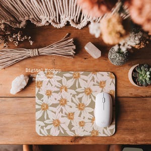 May include: A white mouse sits on a green and white floral mousepad. The mousepad is on a wooden table with a crystal, dried flowers, and a potted succulent.