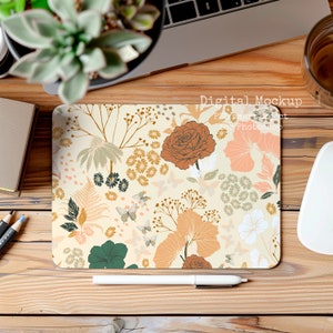 May include: A digital mockup of a mouse pad with a floral pattern. The mouse pad is on a wooden desk with a laptop, a plant, a pen, and a cup of coffee.