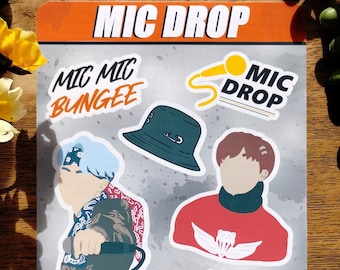 May include: A sticker sheet with various illustrations and text. The top of the sheet reads "MIC DROP" in white and orange. The sheet includes images of a microphone, a DJ mixer, and stylized figures.