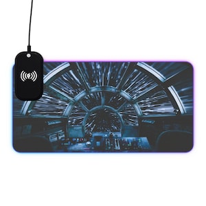 Könnte beinhalten: Eine blaue und weiße Mauspad mit einem Star Wars-Motiv des Millennium Falcon Cockpits. Das Bild zeigt das Innere des Cockpits mit Blick auf die Sterne und den Hyperspace-Effekt. Die Mauspad hat einen violetten Rand.