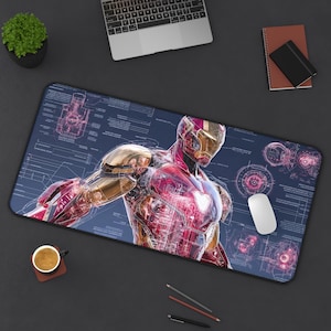 May include: A rectangular desk mat featuring a detailed blueprint-style graphic of a red and gold armored character. The design includes technical schematics, lines, and circular diagrams in shades of blue, white, and red across the surface.