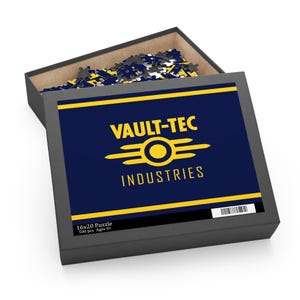 May include: A black box with a navy blue lid featuring the words "VAULT-TEC INDUSTRIES" in yellow. The box contains a 16x20 inch, 500-piece puzzle with the same design. The puzzle pieces are visible inside the box.