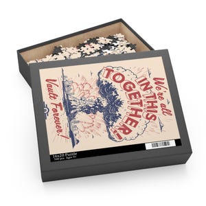 May include: A black puzzle box with a retro-style design. The box features a graphic of a mushroom cloud with the text "We're all in this together!" and "Vault Forever!" The puzzle is 16x20 inches and contains 500 pieces.