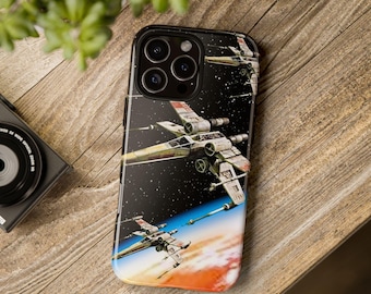 May include: A black smartphone case featuring a graphic print of multiple white and red starfighter spacecraft flying through deep space above a glowing orange planet surface, with a starry black background and visible camera lens cutouts.