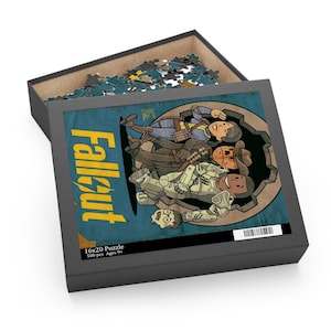 May include: A Fallout-themed puzzle in a black box. The puzzle image features cartoon characters in a circular design with the word "Fallout" in yellow. The box is open, revealing puzzle pieces.