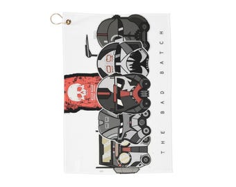 May include: A white golf towel with a black and white illustration of a group of clone troopers from the Star Wars: The Bad Batch animated series. The text "THE BAD BATCH" is written vertically on the right side of the towel.