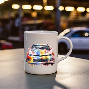 Op de afbeelding: Witte keramische mok met een kleurrijke aquarel-illustratie van een rode, gele, blauwe en groene sportwagen. De auto heeft een zwarte grille en zwarte koplampen.