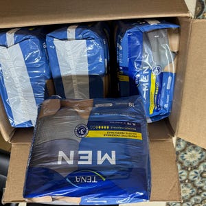 以下が含まれることがあります： TENA MENの保護用下着が複数入った段ボール箱。 パッケージは青と白で、「MEN」の文字が目立つように表示されています。 パッケージは密封されています。