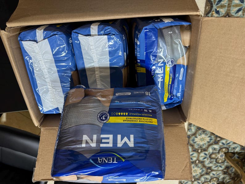 以下が含まれることがあります： TENA MENの保護用下着が複数入った段ボール箱。 パッケージは青と白で、「MEN」の文字が目立つように表示されています。 パッケージは密封されています。