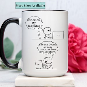 May include: White ceramic mug with a black handle and rim, featuring a humorous cartoon. The cartoon shows two stick figures with thought bubbles that read "Click on My computer" and "How can I click on your computer from my computer?" The text "More Sizes Available" is also visible.