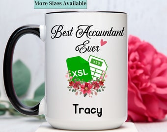 May include: White ceramic coffee mug with a black handle. The mug has a design that says "Best Accountant Ever" with a green spreadsheet icon and a red heart. The name "Tracy" is printed below the design.