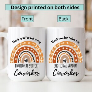 May include: White ceramic mug with a rainbow design and the text "Thank you for being my Emotional Support Coworker". The design is printed on both sides of the mug.