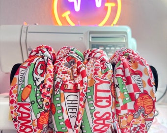 Può includere: Quattro scrunchies per capelli rossi, bianchi e verdi con tema Kansas City Chiefs. Gli scrunchies presentano una varietà di grafiche, tra cui il logo della squadra, le parole "Kansas City Chiefs" e un campo da calcio.