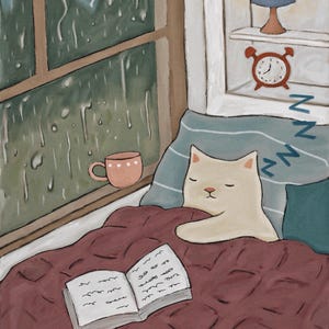 May include: A white cat sleeps under a red blanket with a book and a cup of tea. The cat is curled up and has its eyes closed. The window behind the cat shows a rainy day.