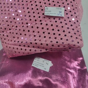 May include: Two fabric samples: one pink sequin knit with black dots and the text "Confetti Sequin Knit Pink", and a shiny fuchsia fabric. The sequin fabric has a tag with "J3" and "BQ-245". The fuchsia fabric has a tag with "C10" and "BU-051".