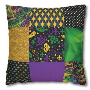 Puede incluir: Una almohada de patchwork con temática de Mardi Gras. La almohada está hecha de diferentes telas con varios patrones, incluyendo purpurina dorada, diamantes verdes y morados, flores de lis verdes y moradas, y máscaras verdes y moradas.