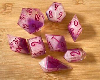 Pink and white " Crystal Song" Polyhedral dice set for dungeons and dragons rulesets.