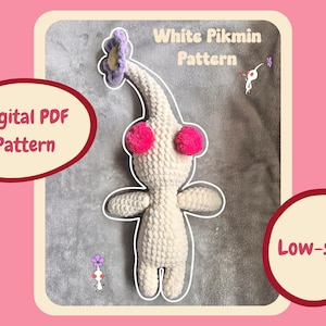 May include: A crocheted white Pikmin plushie with pink pom-pom cheeks and a purple flower head. The image includes text that reads "White Pikmin Pattern", "Digital PDF Pattern", and "Low-sew!"