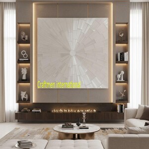 May include: A modern living room with a large, abstract artwork as a focal point. The artwork is a radial design in shades of white. The room features built-in shelving, a fireplace, and a low coffee table. The text "Craftmen international" is visible.