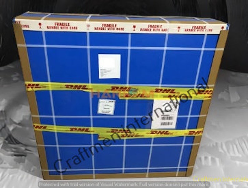 Puede incluir: Una caja de cart&oacute;n rectangular grande con envoltorio azul y cinta adhesiva amarilla de DHL. La caja est&aacute; etiquetada como "FR&Aacute;GIL MANIPULAR CON CUIDADO" y tiene varias etiquetas de env&iacute;o. La caja est&aacute; envuelta con cinta amarilla que dice "DHL".