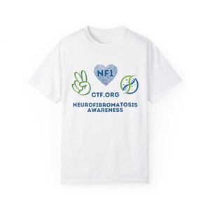May include: White t-shirt featuring a green peace sign, a blue heart with the text "NF1" inside, and a blue and green DNA strand. The text "CTF.ORG" and "NEUROFIBROMATOSIS AWARENESS" is printed below the symbols.