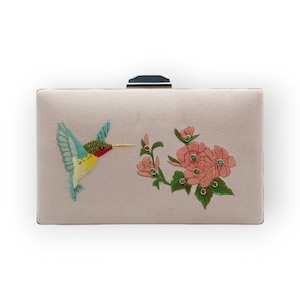 Impresionante clutch rosa con un colibrí posado sobre flores vibrantes. Perfecto para una salida nocturna o una ocasión especial.