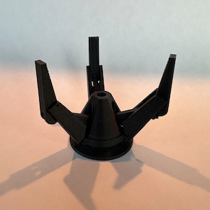 May include: A black 3D printed object with four arms that extend out from a central base. The arms are hinged and can be moved to different positions.
