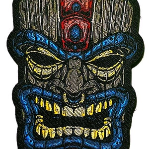 May include: A blue and yellow tiki mask with a red and blue headdress. The mask has a carved wooden appearance and a fierce expression.