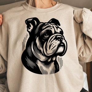May include: A beige sweatshirt with a black and white illustration of a bulldog's head.
