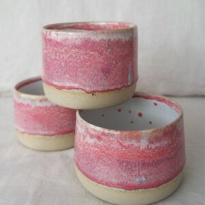 Wheel thrown handmade ceramic cup in pink tones. Handleless mug made with Australian clay, dishwasher and microwave safe. A pottery coffee cup that’s unique, smooth, and ideal for daily use.