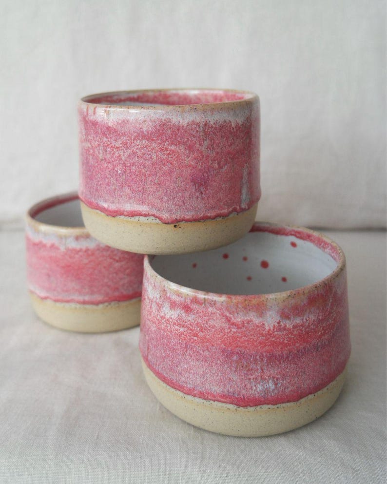 Wheel thrown handmade ceramic cup in pink tones. Handleless mug made with Australian clay, dishwasher and microwave safe. A pottery coffee cup that’s unique, smooth, and ideal for daily use.