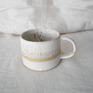 Rustic brown and white ceramic mug, handmade pottery gift, crafted with natural clay for a cozy coffee experience.