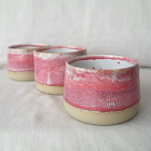 Pink ceramic handleless cup handmade on the wheel. Unique pottery mug made in Australia with a glossy glaze. Food safe, dishwasher safe, and gift wrapped, ideal for gifting.