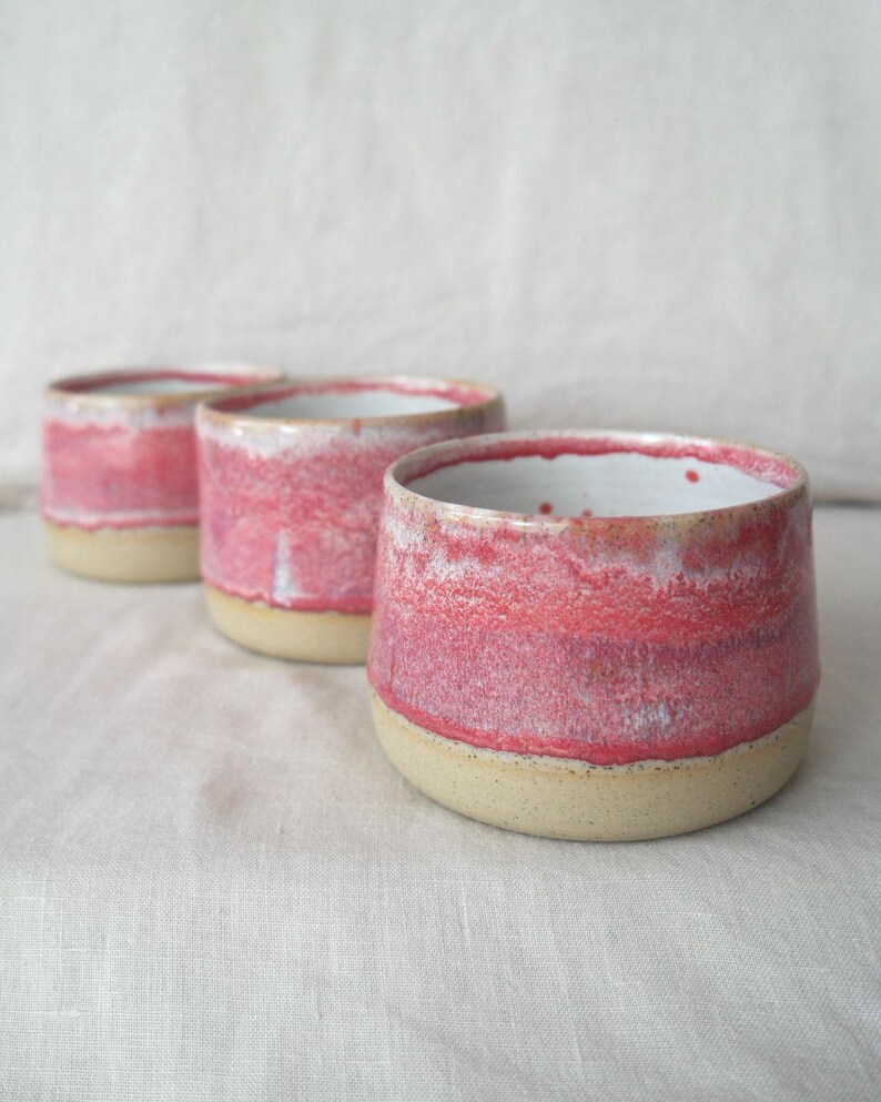 Pink ceramic handleless cup handmade on the wheel. Unique pottery mug made in Australia with a glossy glaze. Food safe, dishwasher safe, and gift wrapped, ideal for gifting.